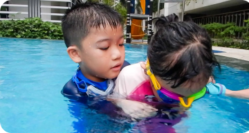 Children swimming with swimming goggles and sun protection