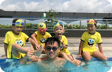 Happy children with instructor sitting by the pool side
