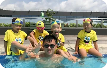 Happy children with instructor sitting by the pool side