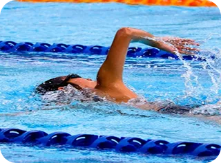 Swimmer training with freestyle stroke in pool lane